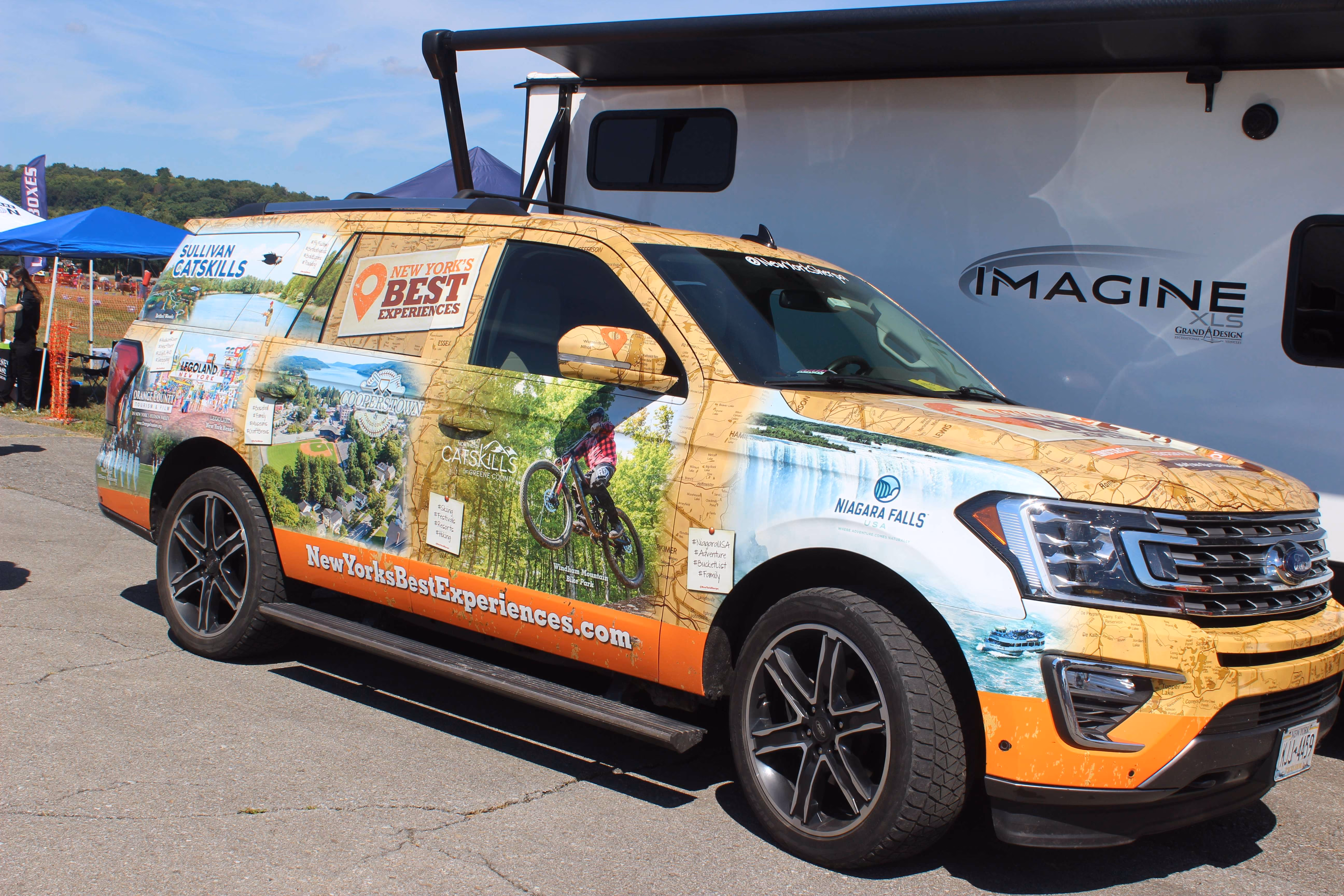 decorated orange vehicle with advertisement on vehicle wrap