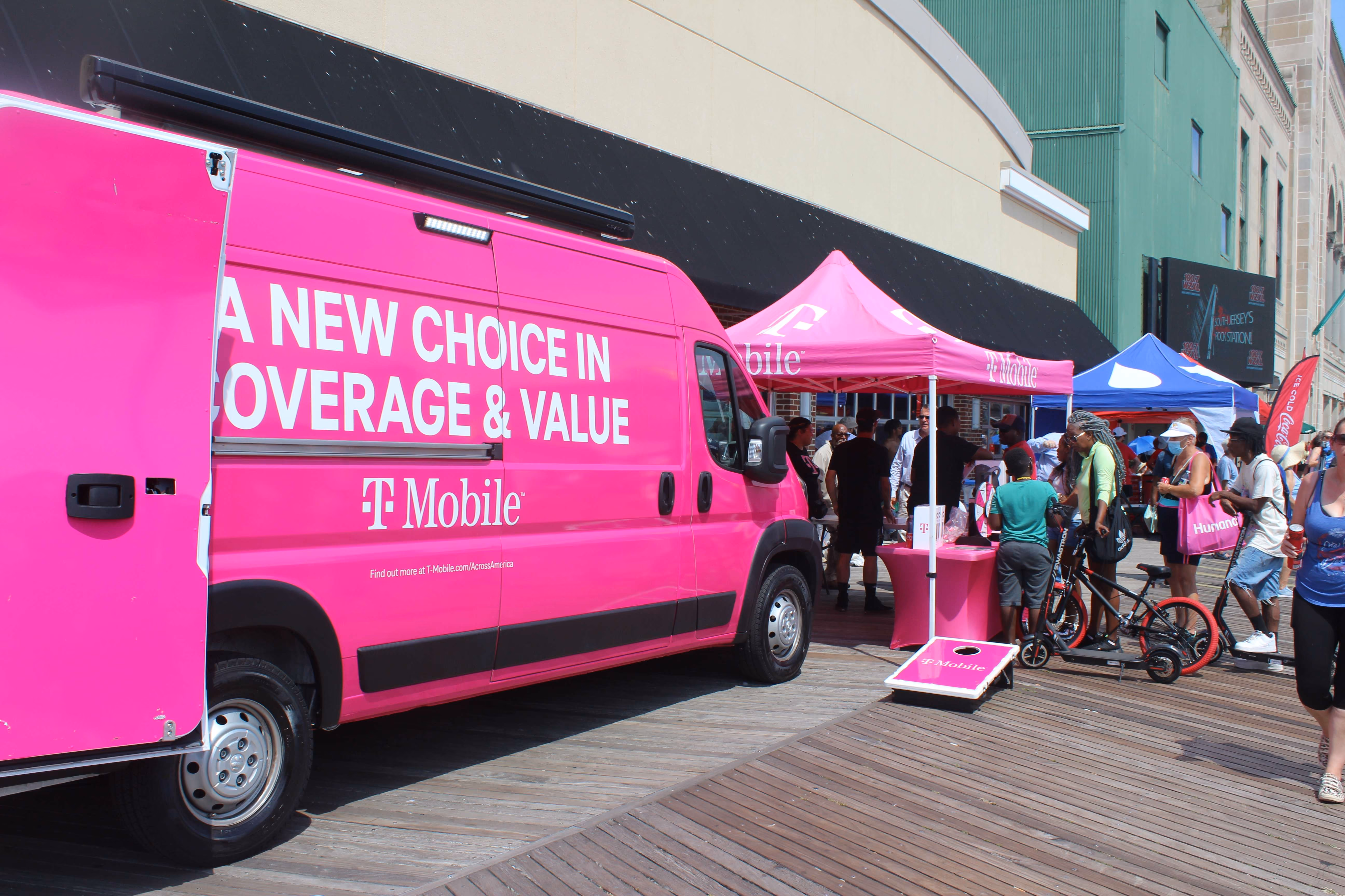 bright pink T mobile van and marketing tent with crowd of people in front