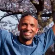 Tiro standing in front of cherry blossom trees.