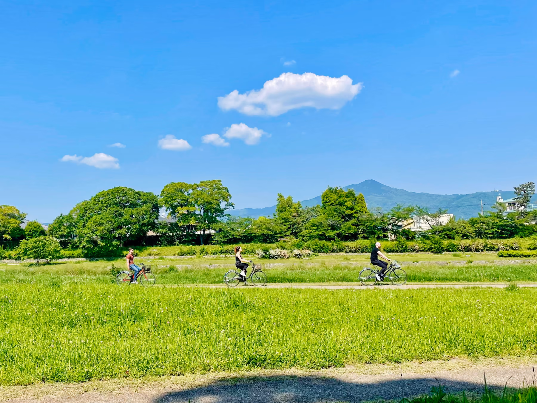 A guided private e-bike tour group riding through a scenic local street in Kyoto with City Rocker Tours.