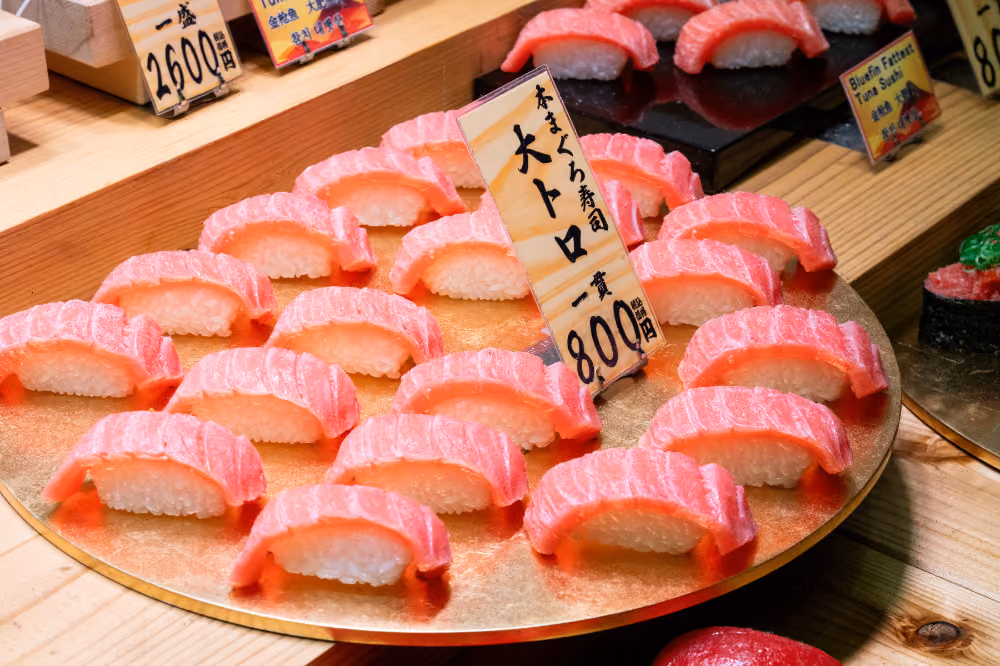 Plate with multiple pieces of pink fatty tuna nigiri sushi arranged around a price sign in Japanese yen.
