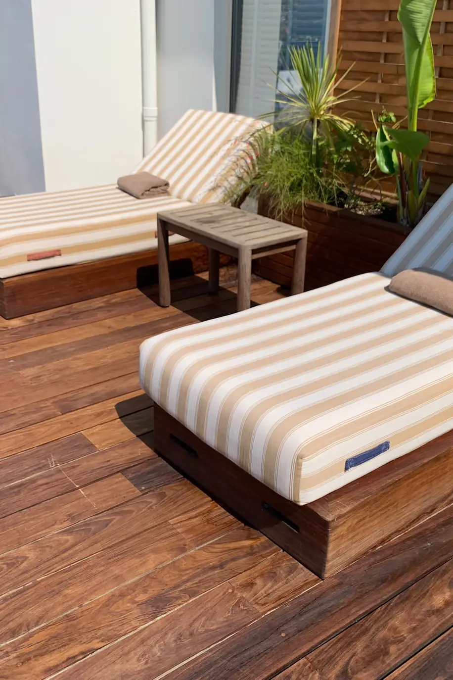 Bains de soleil à rayures sur une terrasse en bois