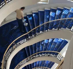 Vue en plongée d'un escalier hélicoïdal à la moquette bleue