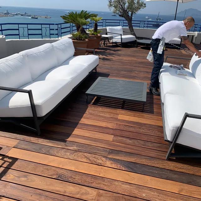 Terrasse en bois avec banquette blanche face à la mer