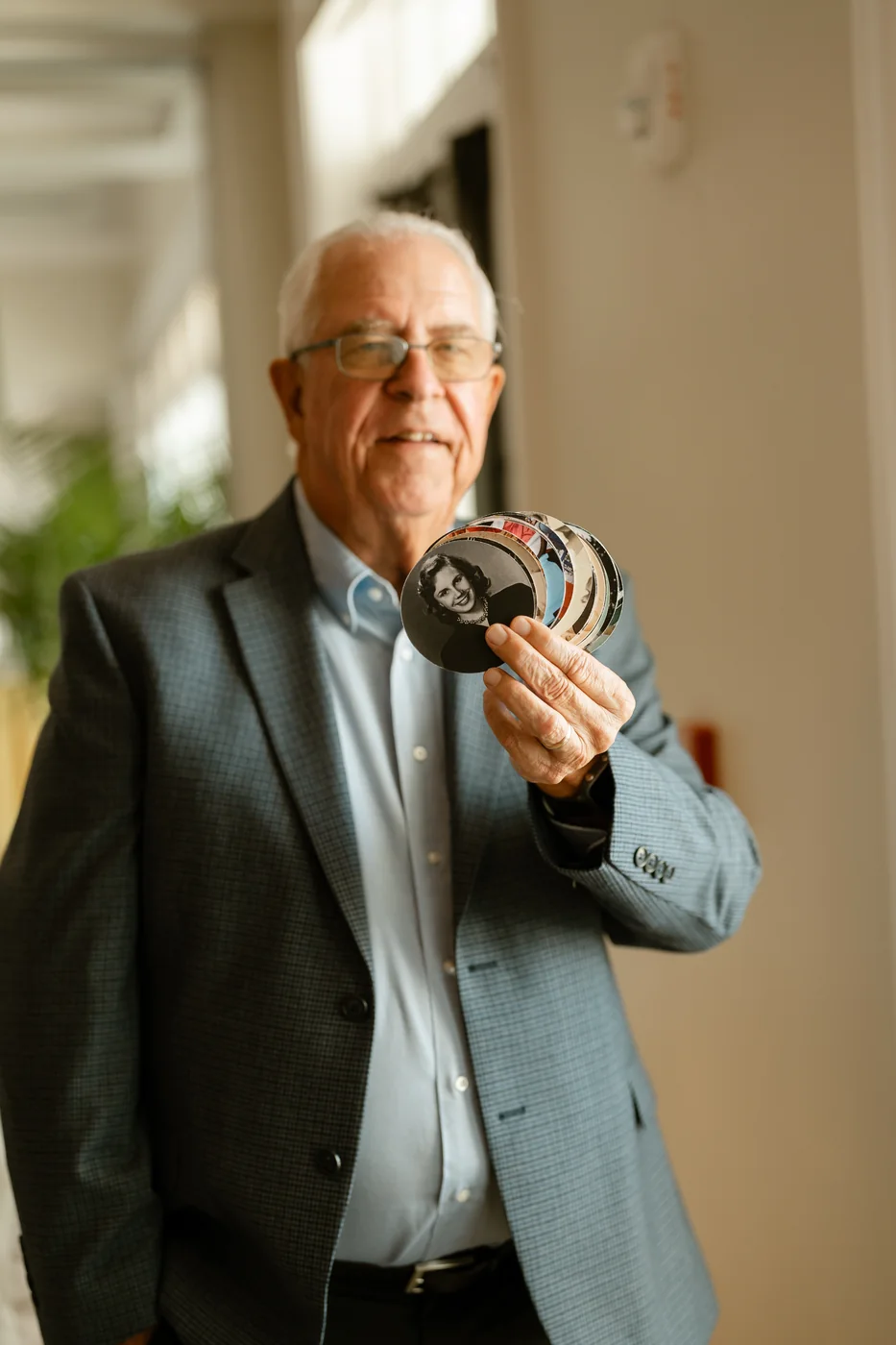 Greg Barber, founder of Eco Friendly Printer, holding a fan of printed photo coasters