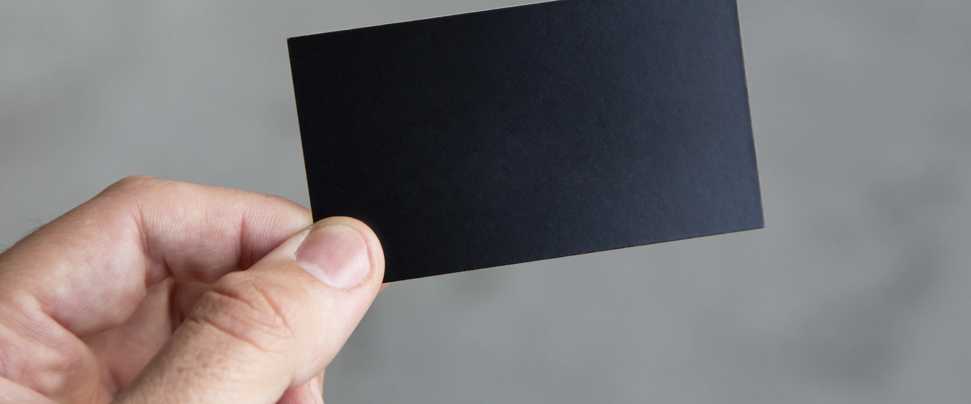 Hand holding a black business card