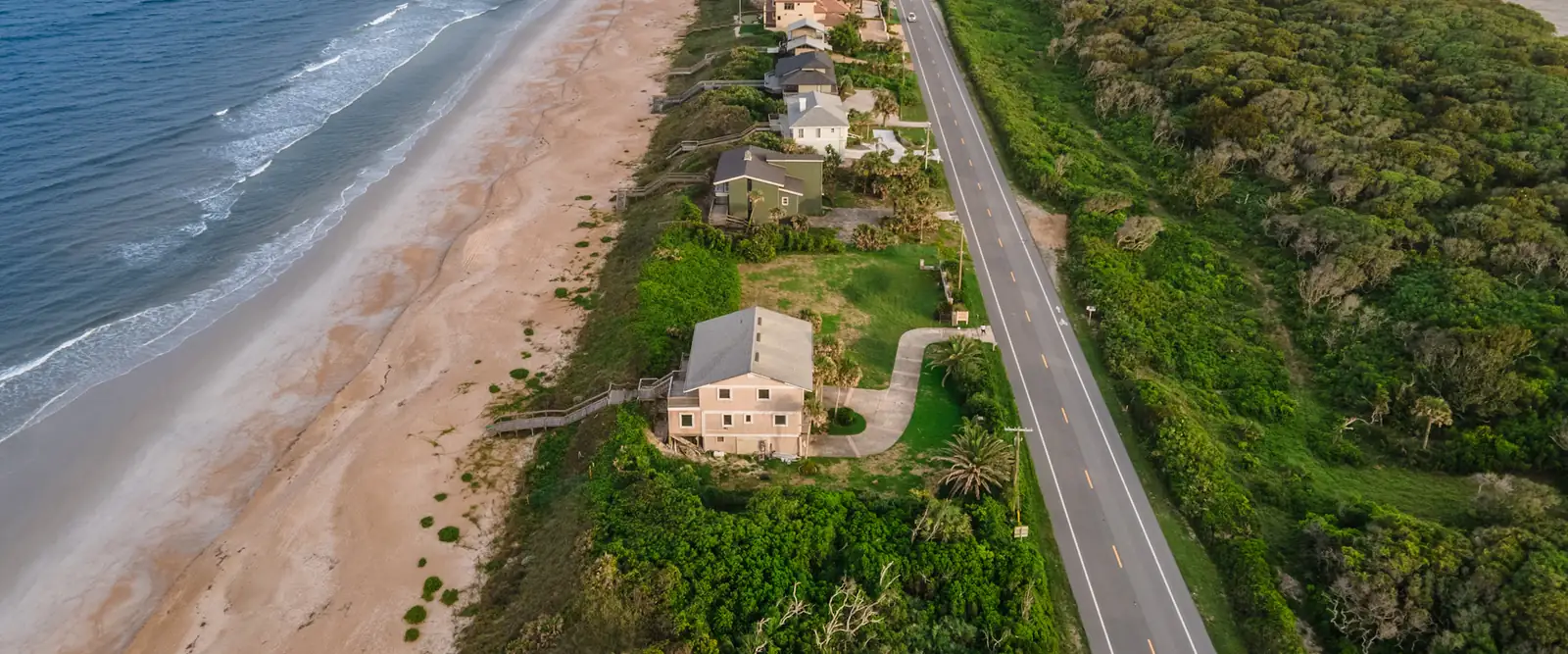 Aerial view of a coastal road running beside the beach