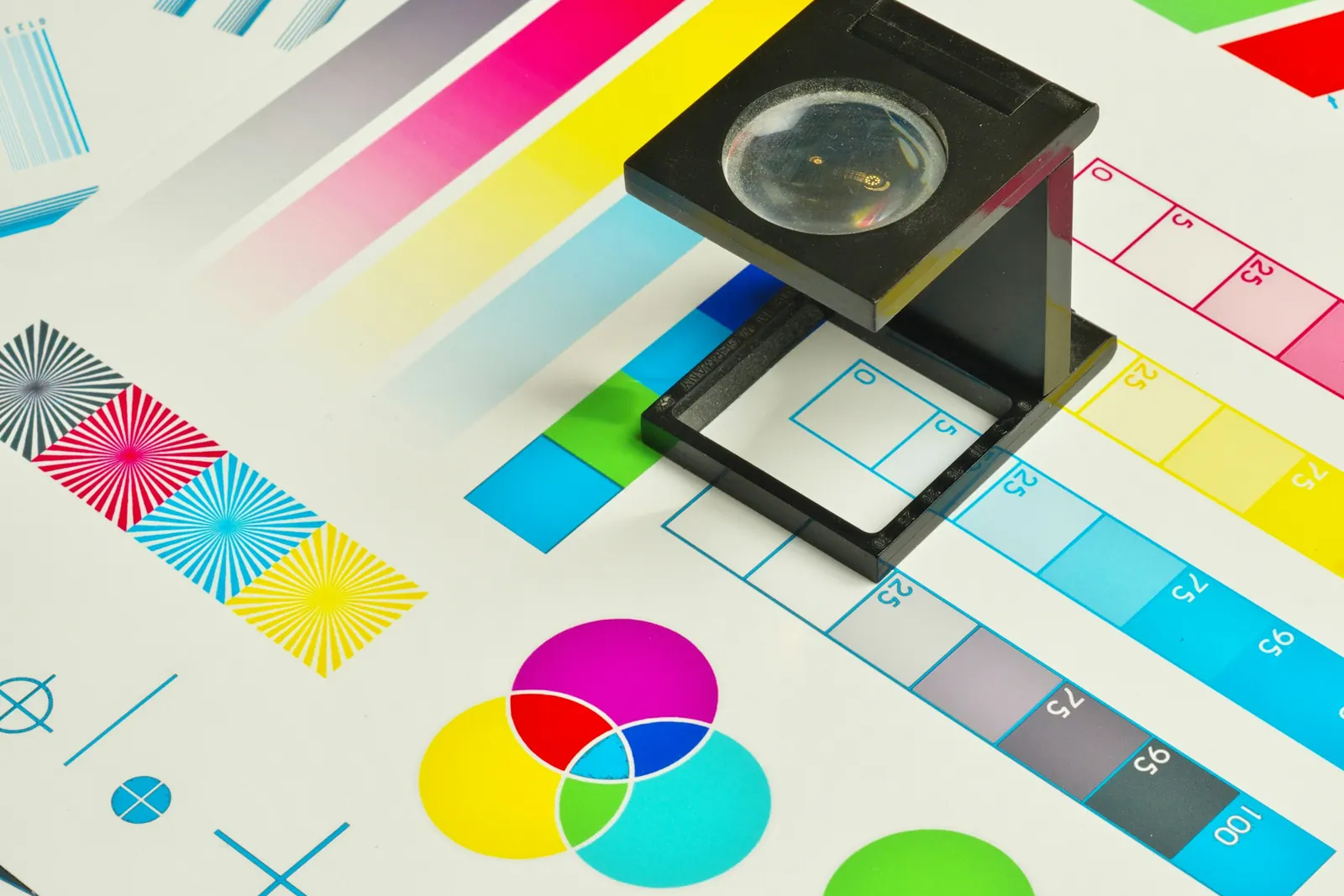A linen tester magnifier on a printed CMYK color chart