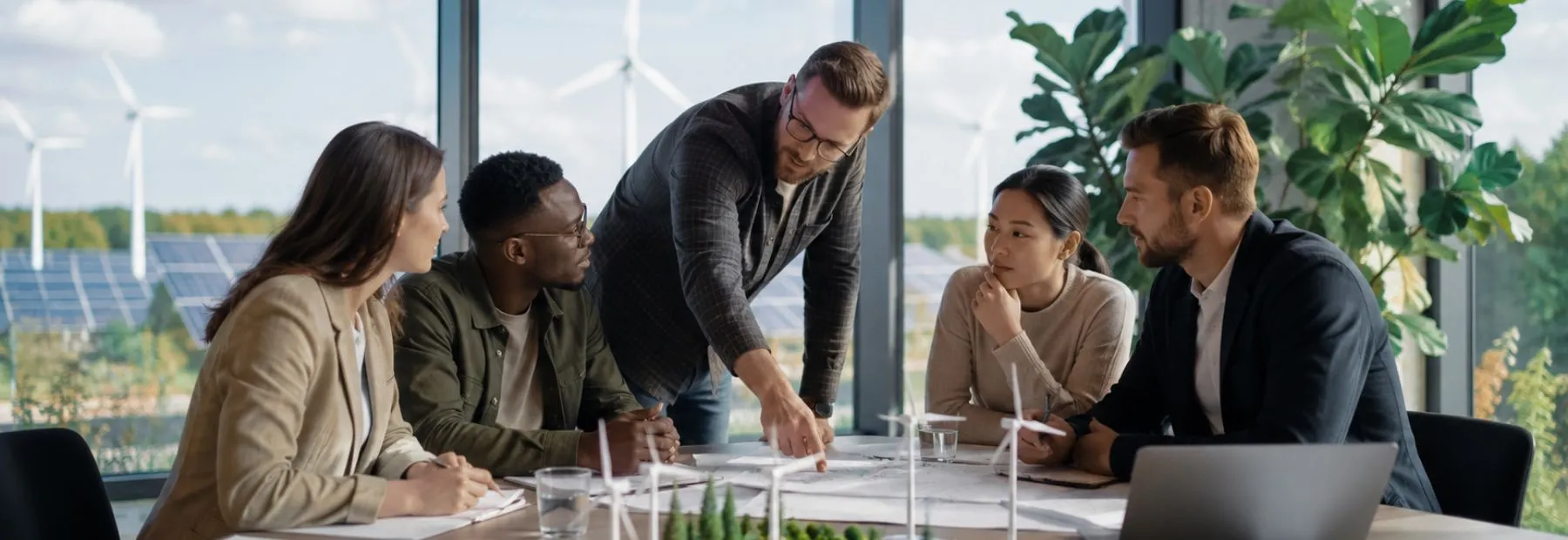 A project team working through a site model around a table