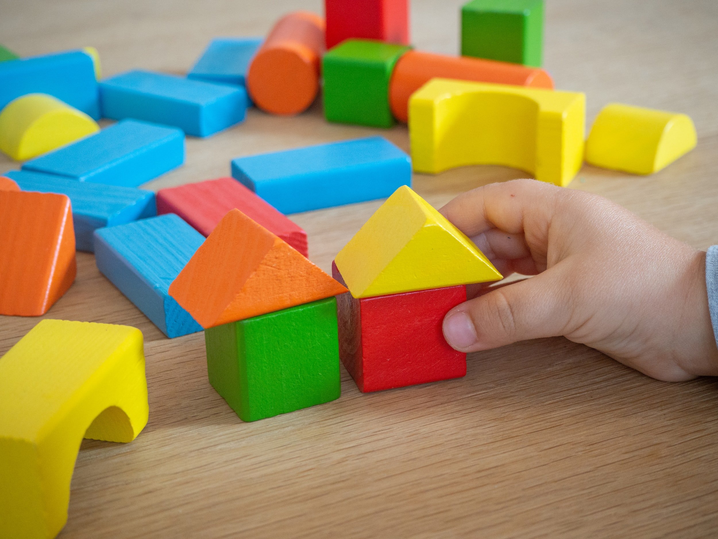 A child building with wooden blocks in play therapy