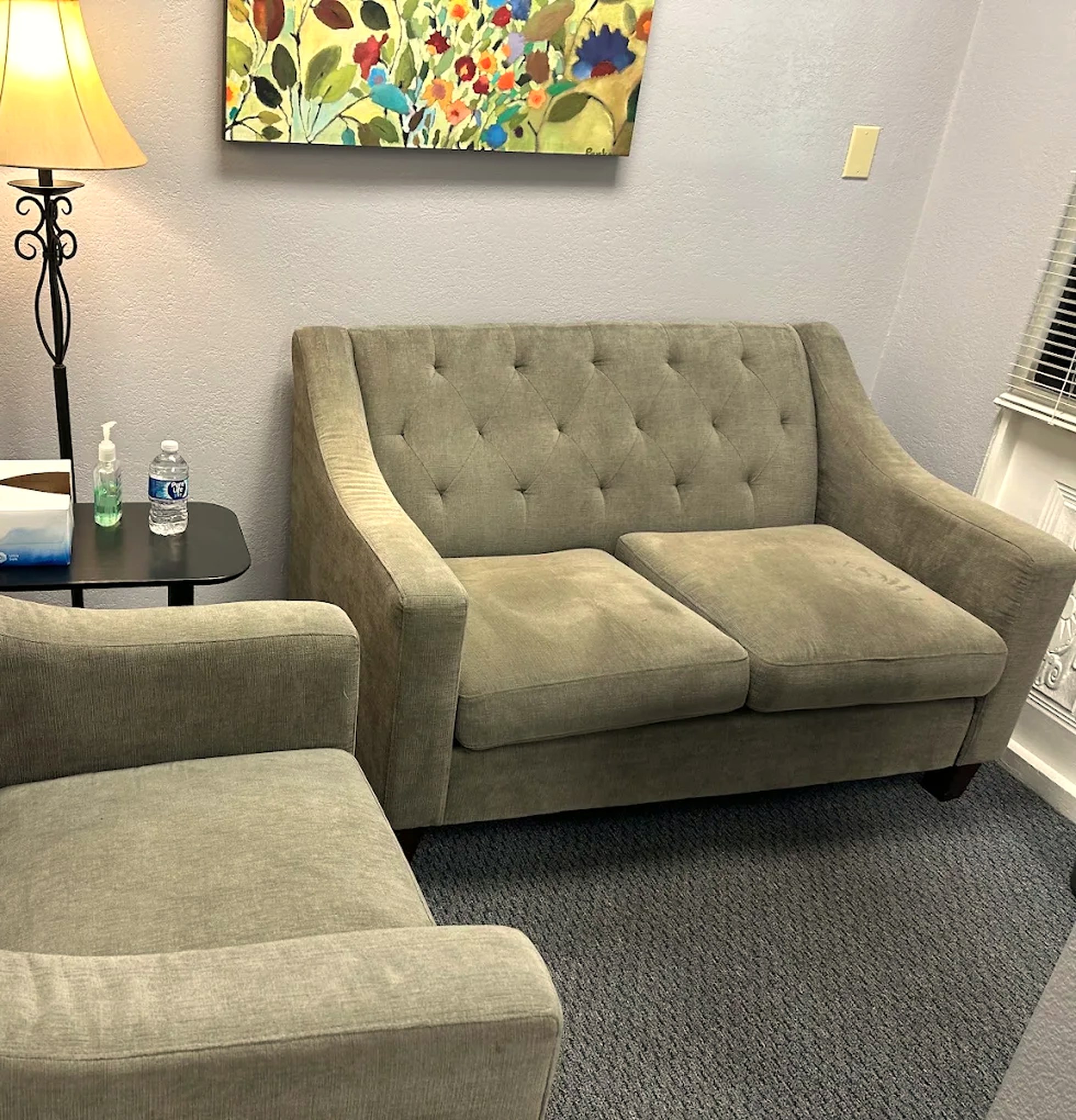 The waiting area at the Redwood City office, with two sofas and a lamp between them