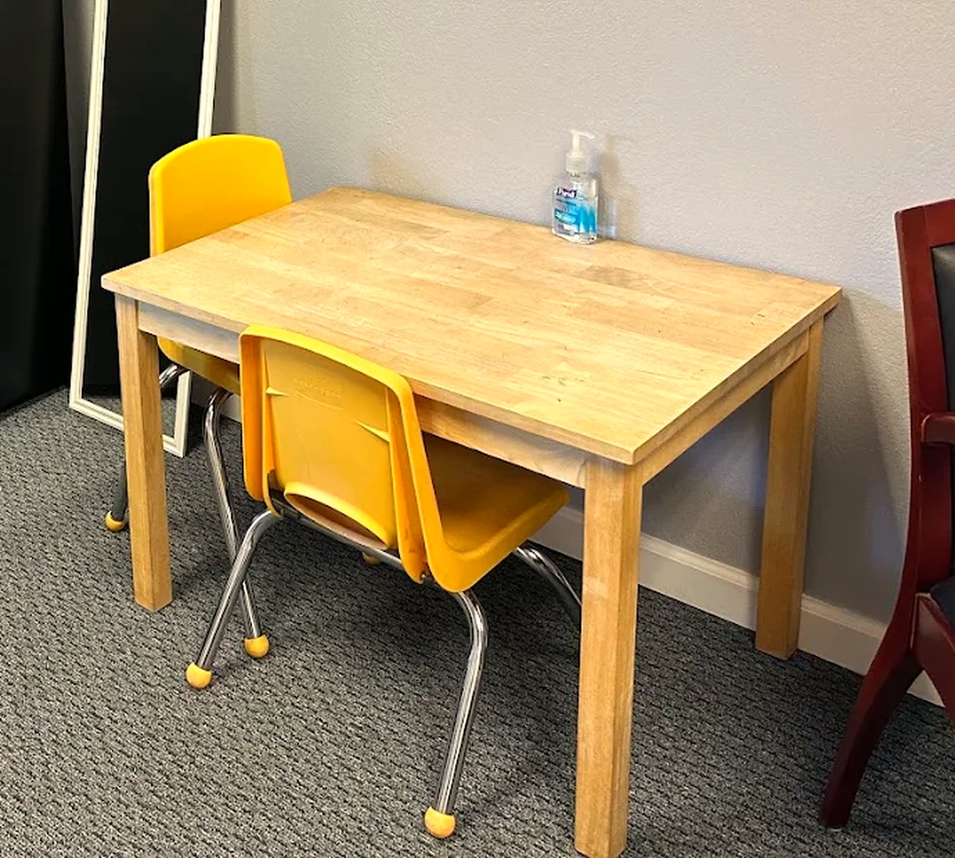 A small wooden table with yellow child-size chairs in the Redwood City play space.