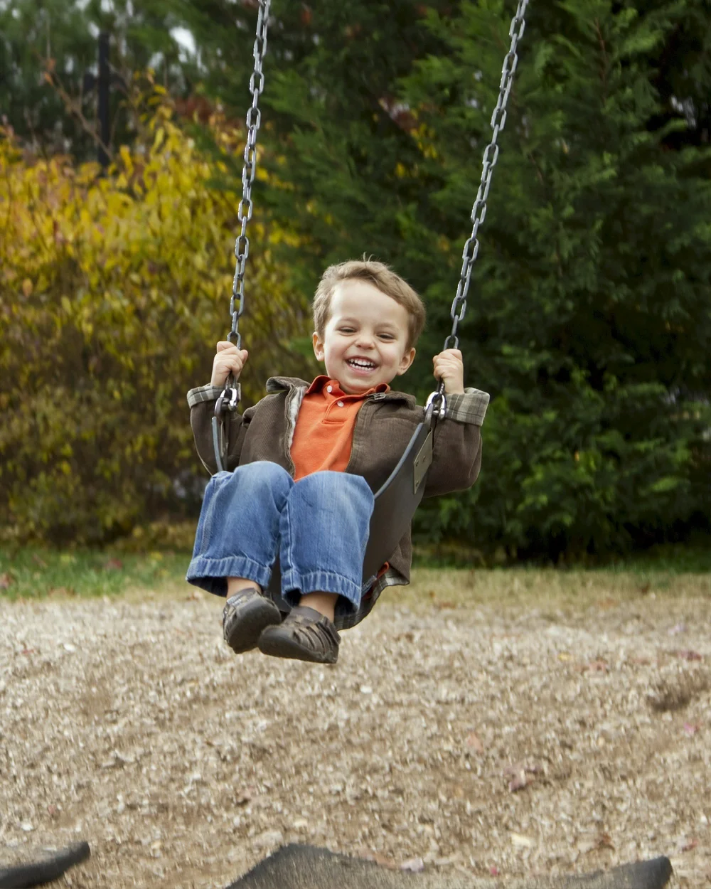 A child laughing on a swing