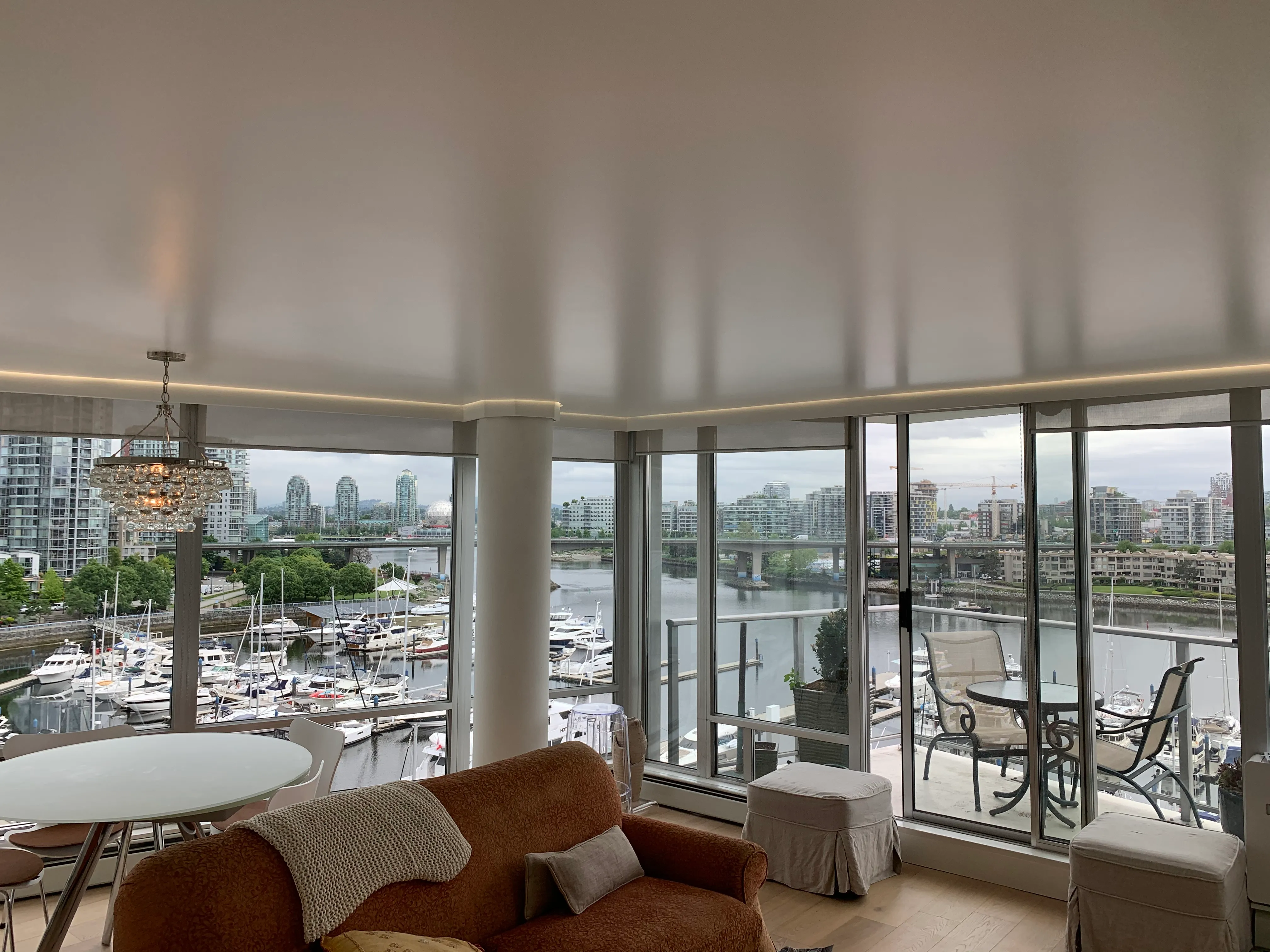 Living room with a seamless stretch ceiling and perimeter cove lighting, finished by Luxury Interior