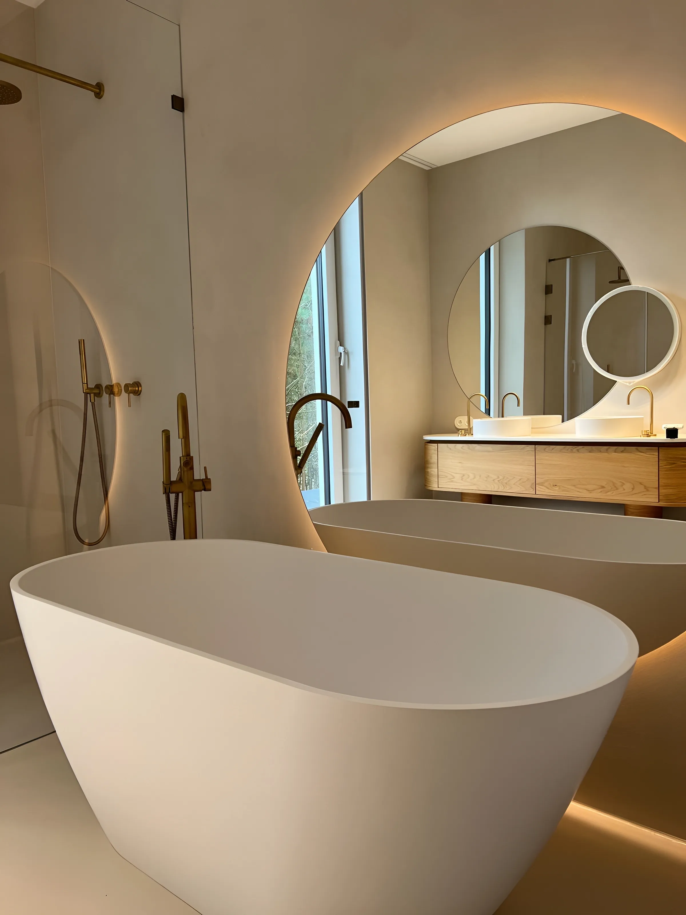 Seamless microcement bathroom with backlit mirror and freestanding tub