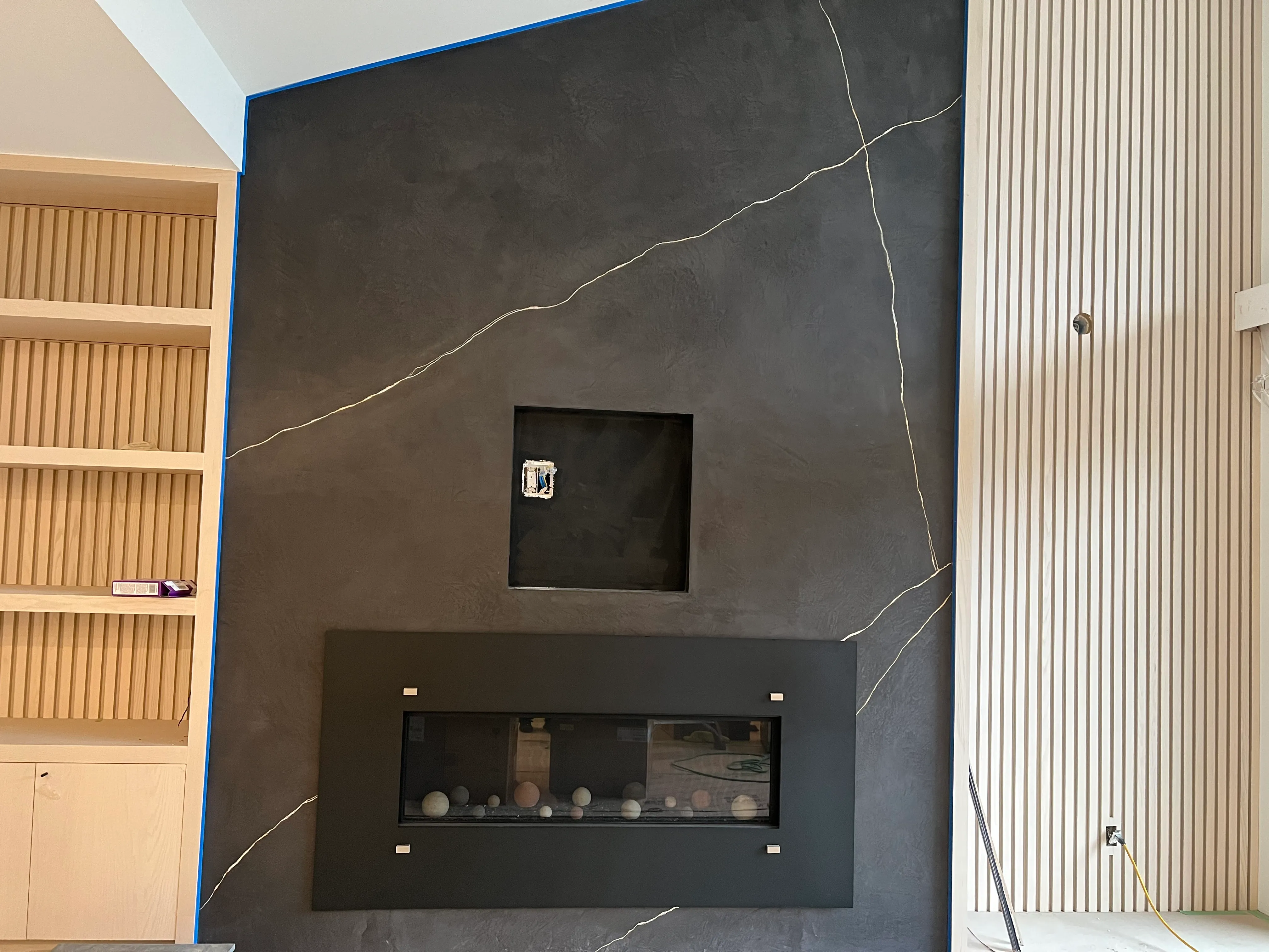 Dark hand-finished fireplace feature wall with gold veining