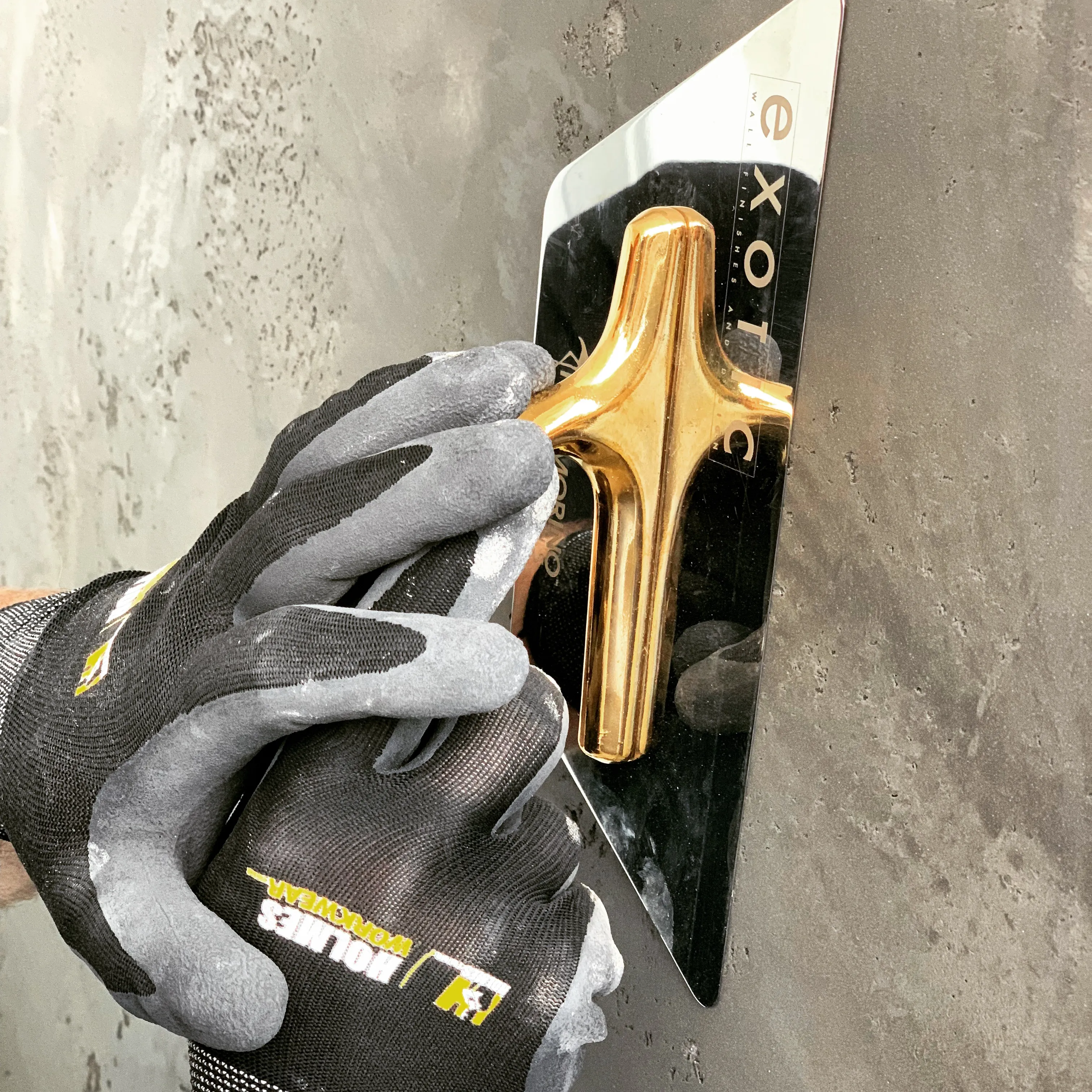 Microcement being hand-applied with a stainless trowel