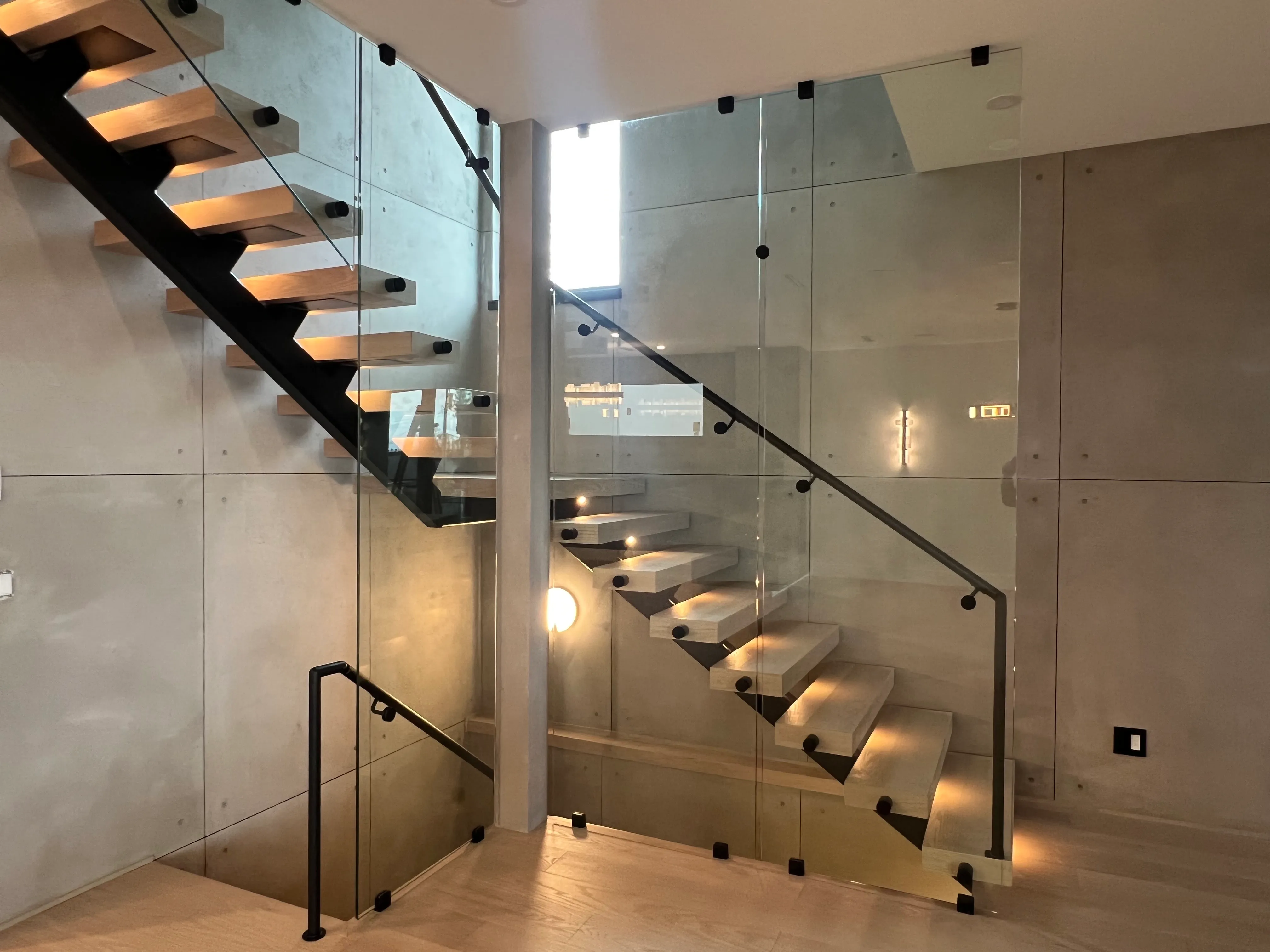 Floating staircase with glass balustrade and integrated step lighting