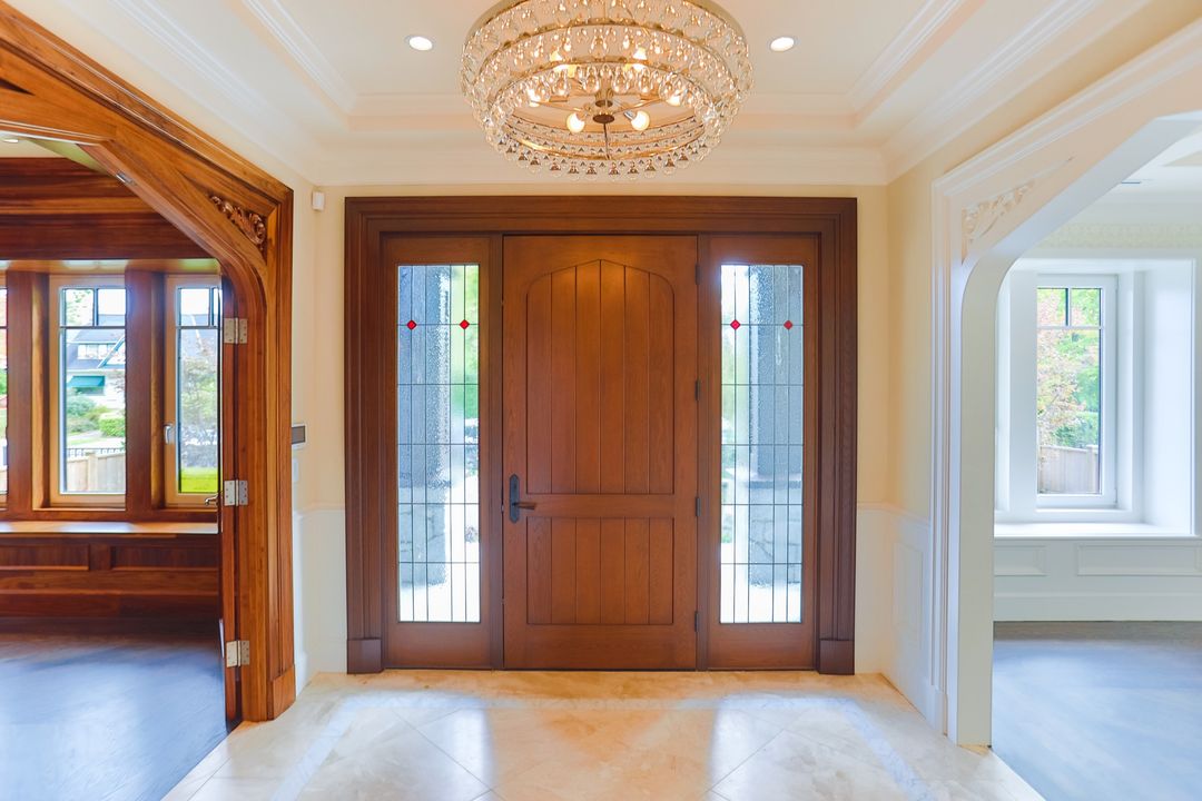 Renovated grand entry with wood doors and leaded glass