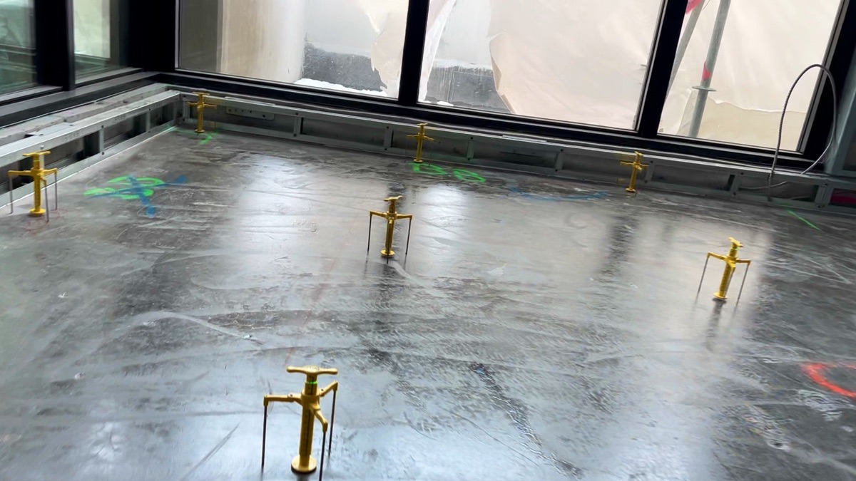 Yellow gauges spread across a glossy floor in a corner room