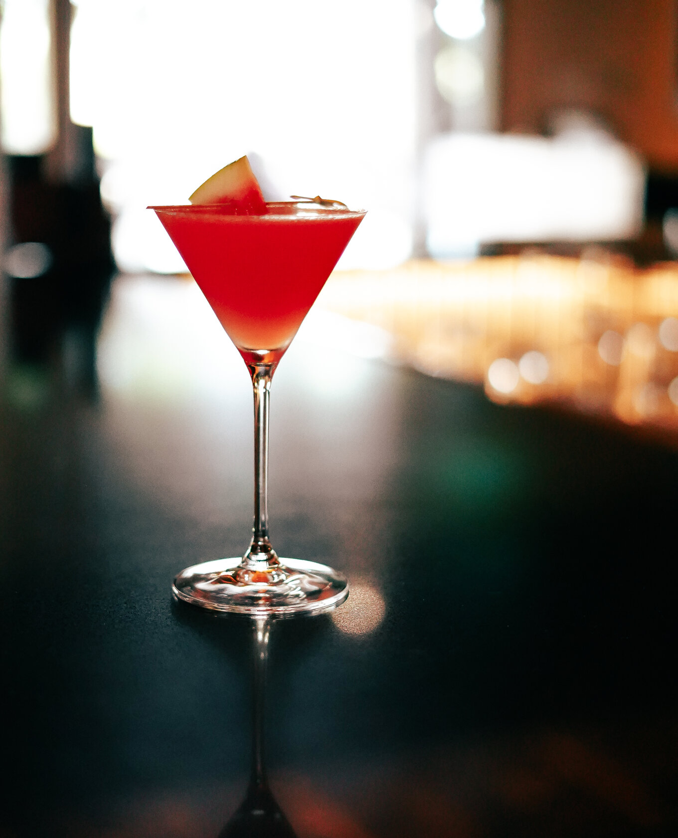 Red cocktail garnished with watermelon at Napkins Bar and Grill