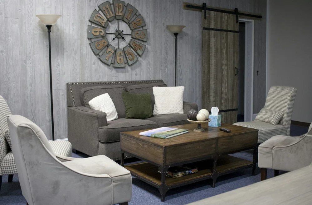 A furnished living room with sofas, armchairs and a coffee table