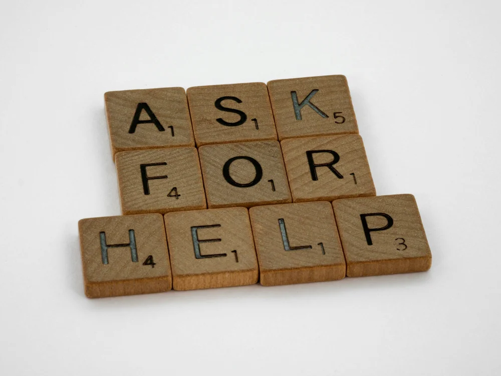 Letter tiles spelling out the words ask for help