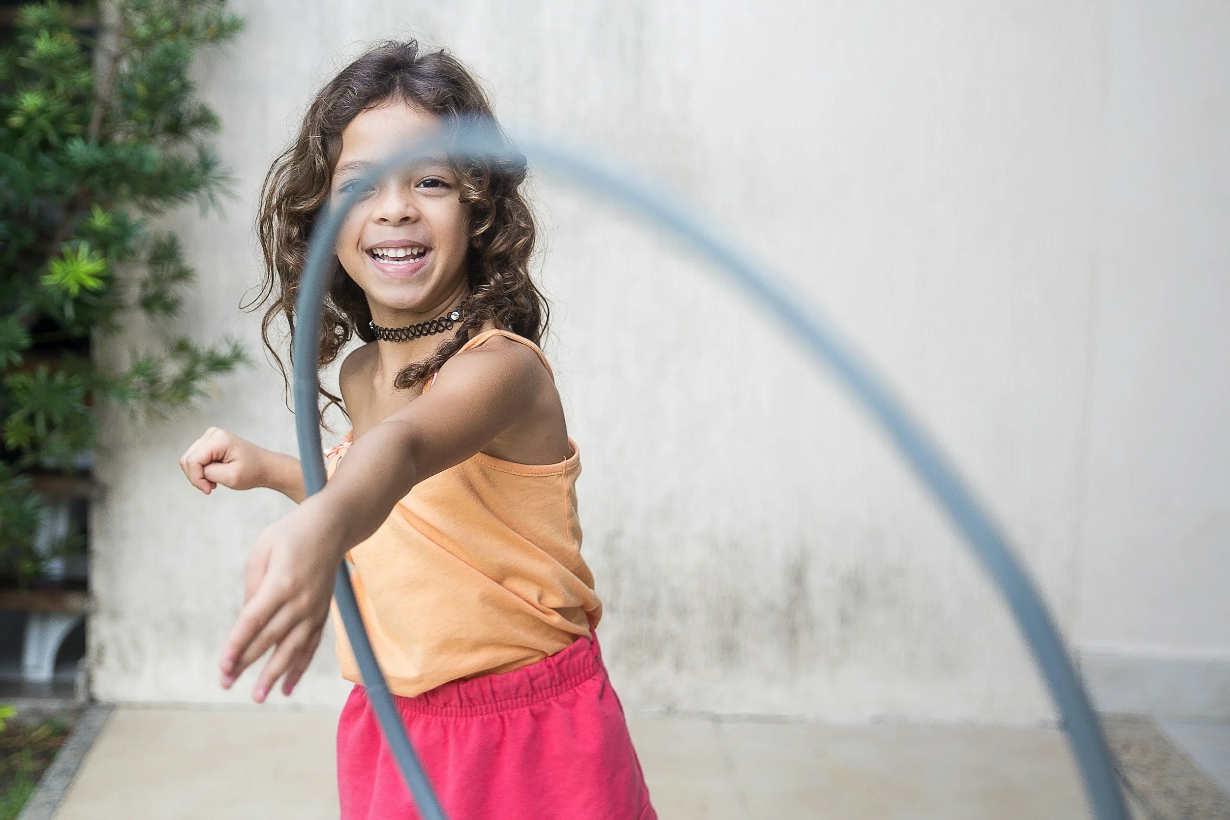 A blindfolded child reaching out during a game beside a wall