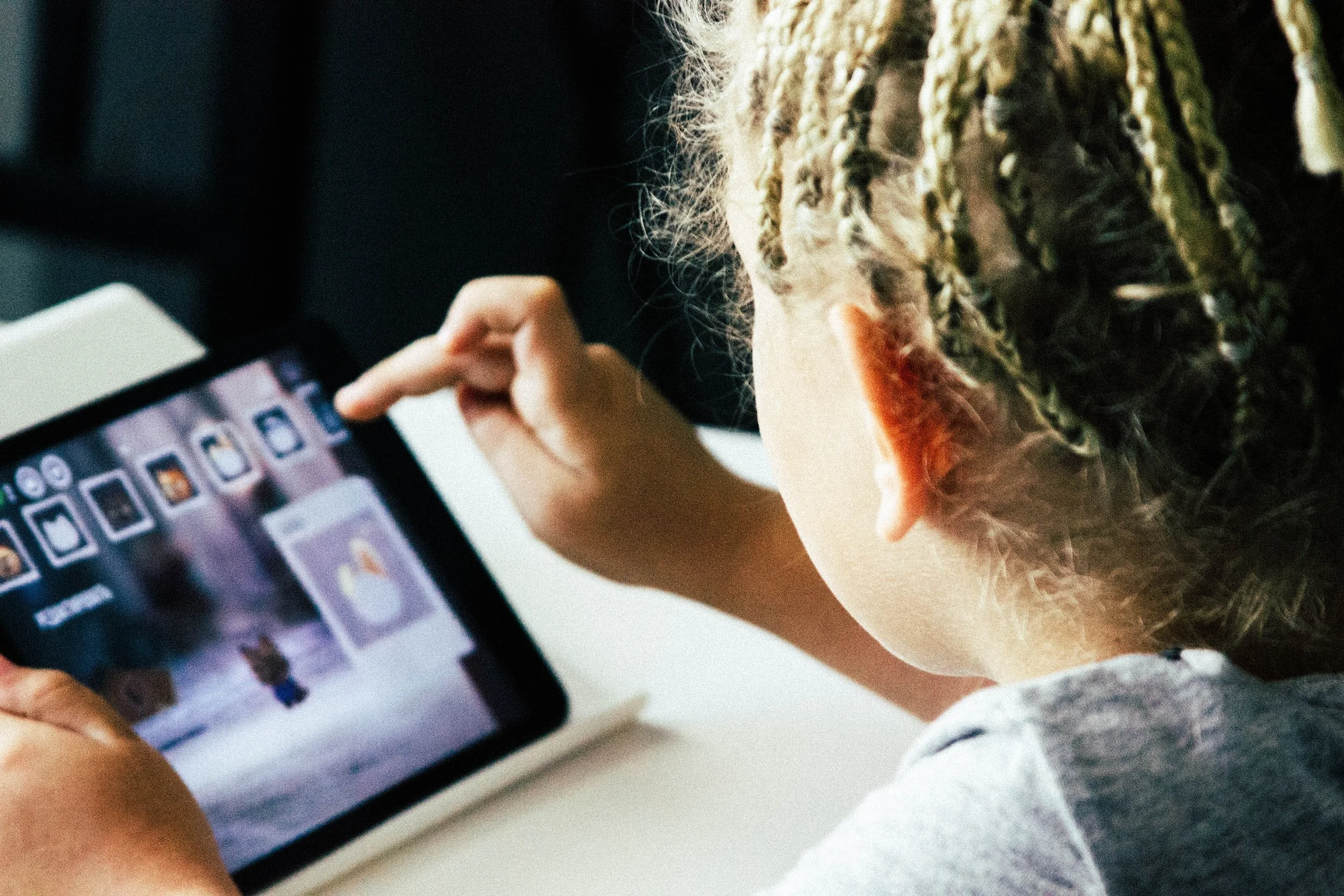 A person scrolling through photos on a tablet