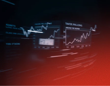 Blurry digital display showing multiple ascending line graphs and charts against a dark background with reddish overlay.
