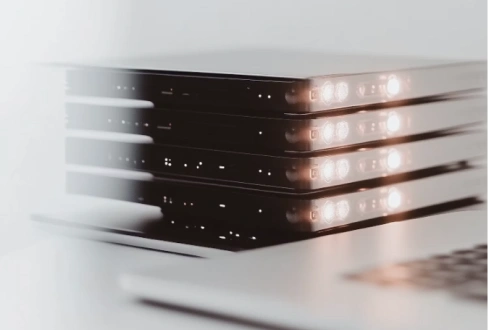 Stack of compact black electronic devices with illuminated indicator lights in a minimalist setting.
