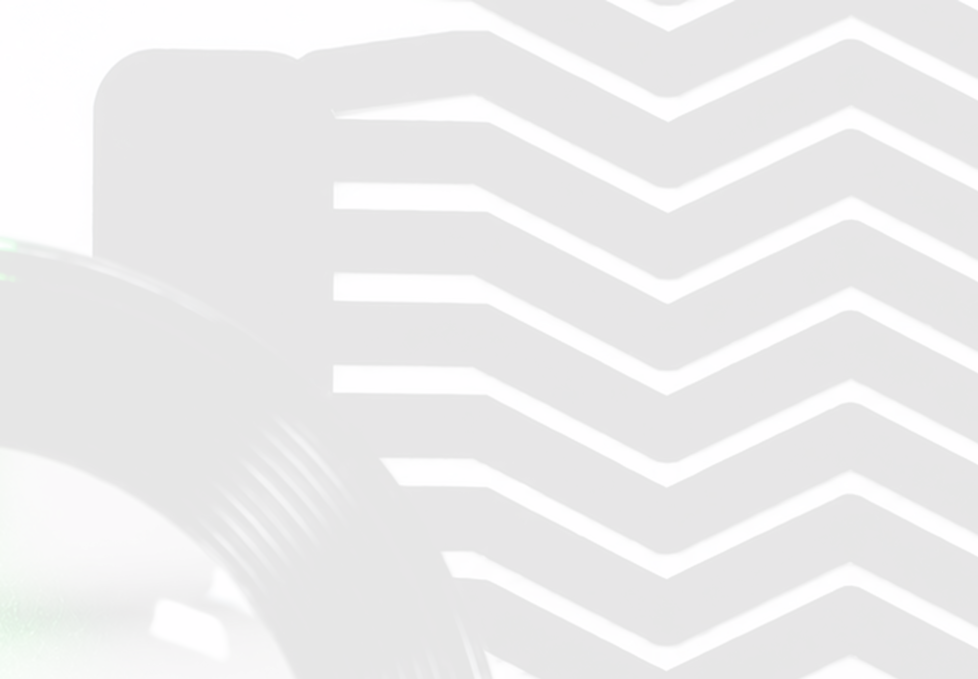 Close-up of a black vinyl record with a green reflection beside a vinyl cover with black and white zigzag patterns.