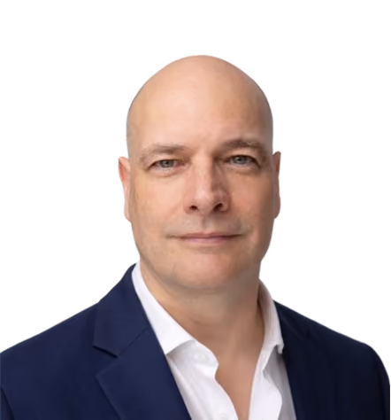 Portrait of a bald man in a navy blazer and white shirt with a neutral expression.