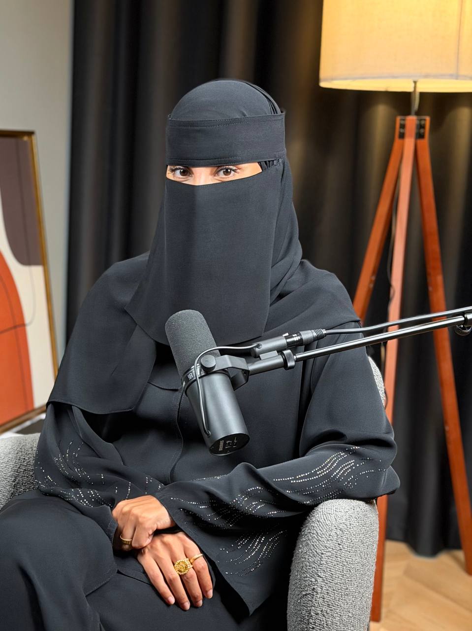 Mariam, fat loss coach, seated at her microphone