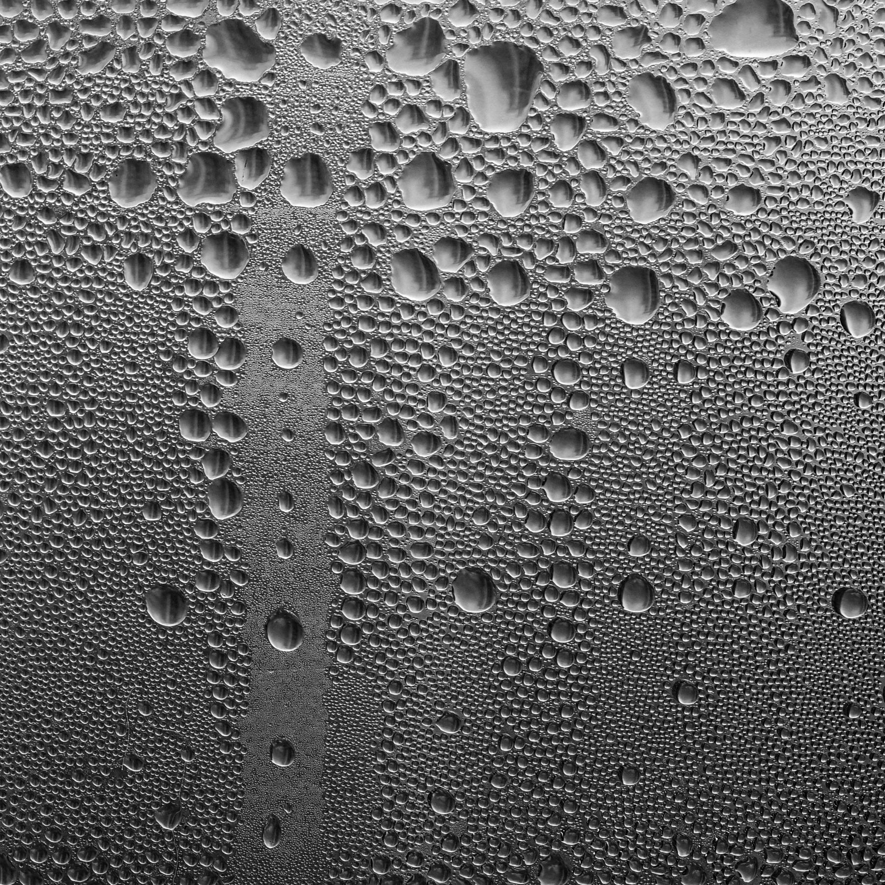Close-up photograph of water droplets collecting on a glass surface