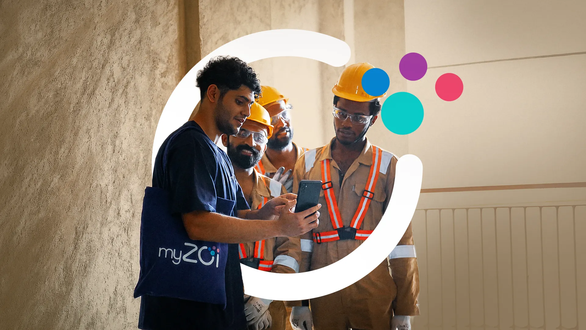 Man with a myZoi bag showing his smartphone to workers in hard hats and safety vests