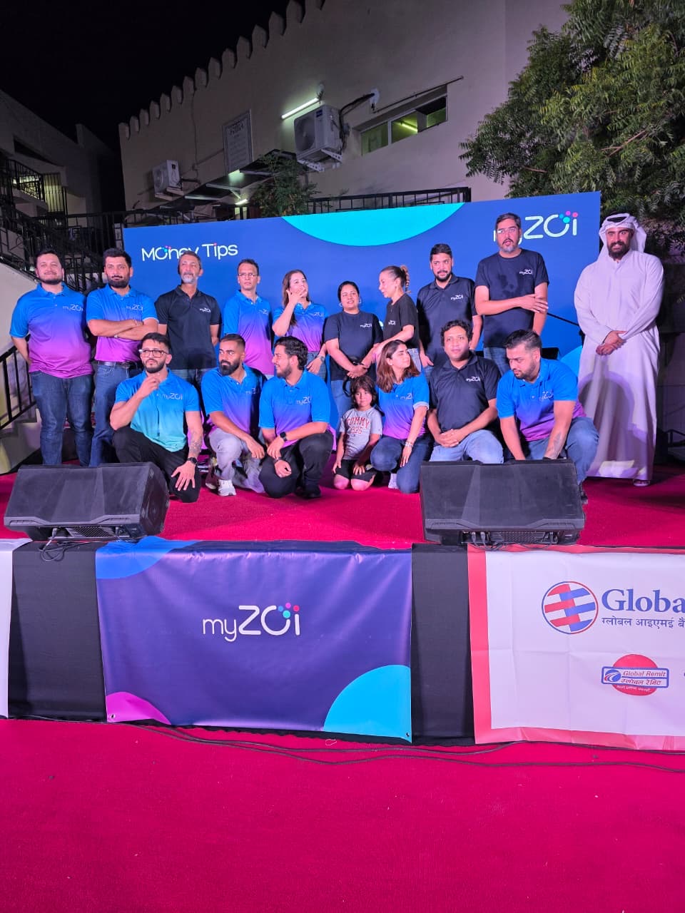 myZoi team posing on stage at an evening MoneyTips community event