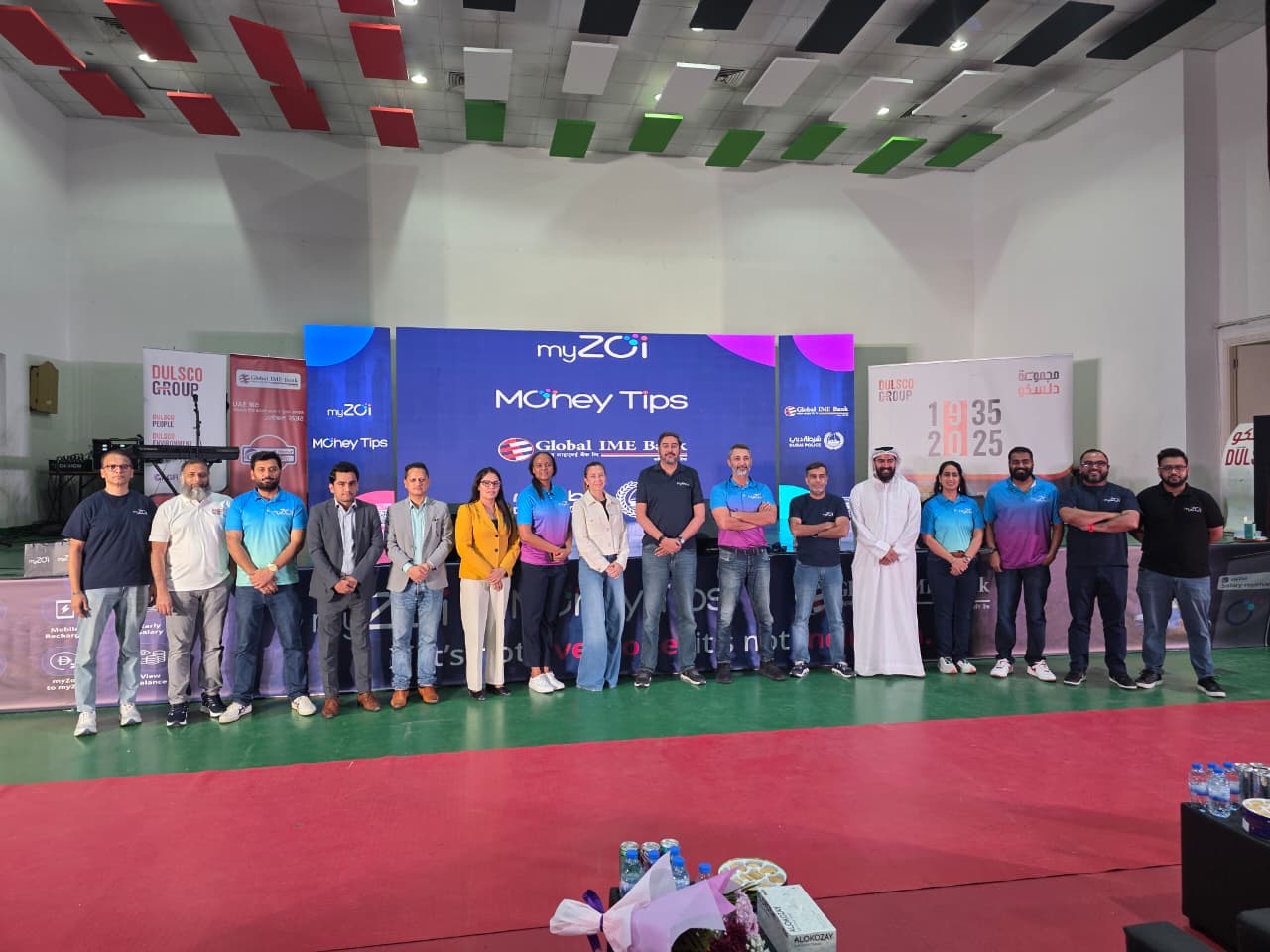 myZoi team and guests standing in front of a MoneyTips stage backdrop