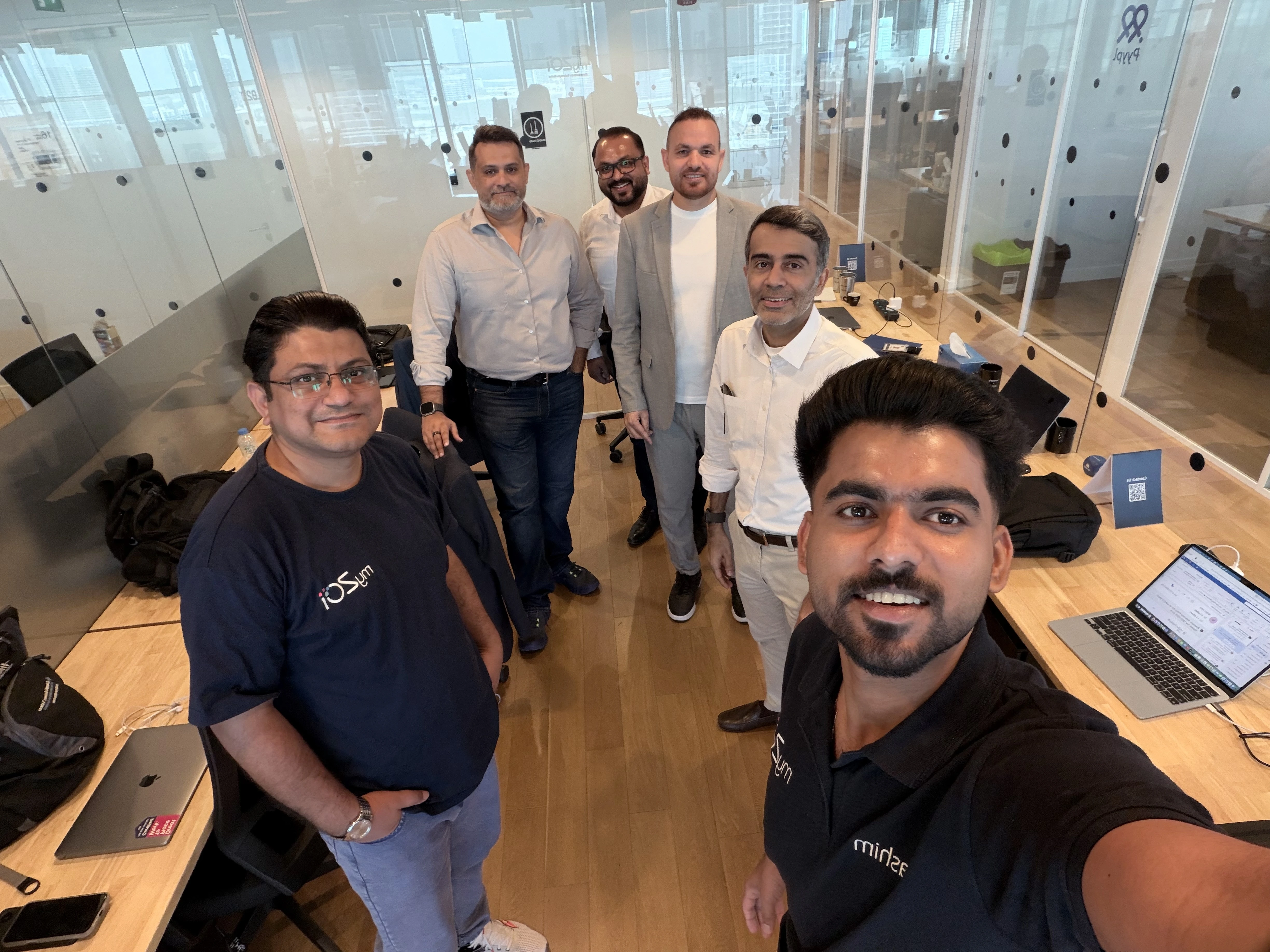Group selfie of team members in an open plan office