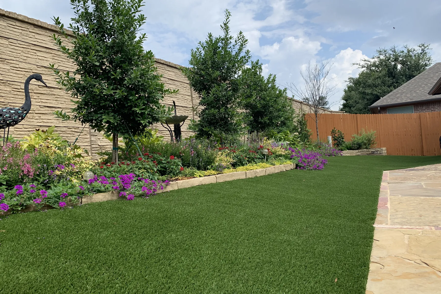 Finished synthetic turf lawn beside a residential swimming pool