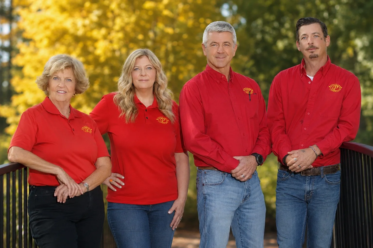 Four members of the Pinckard Landscape family team standing together outdoors in company shirts