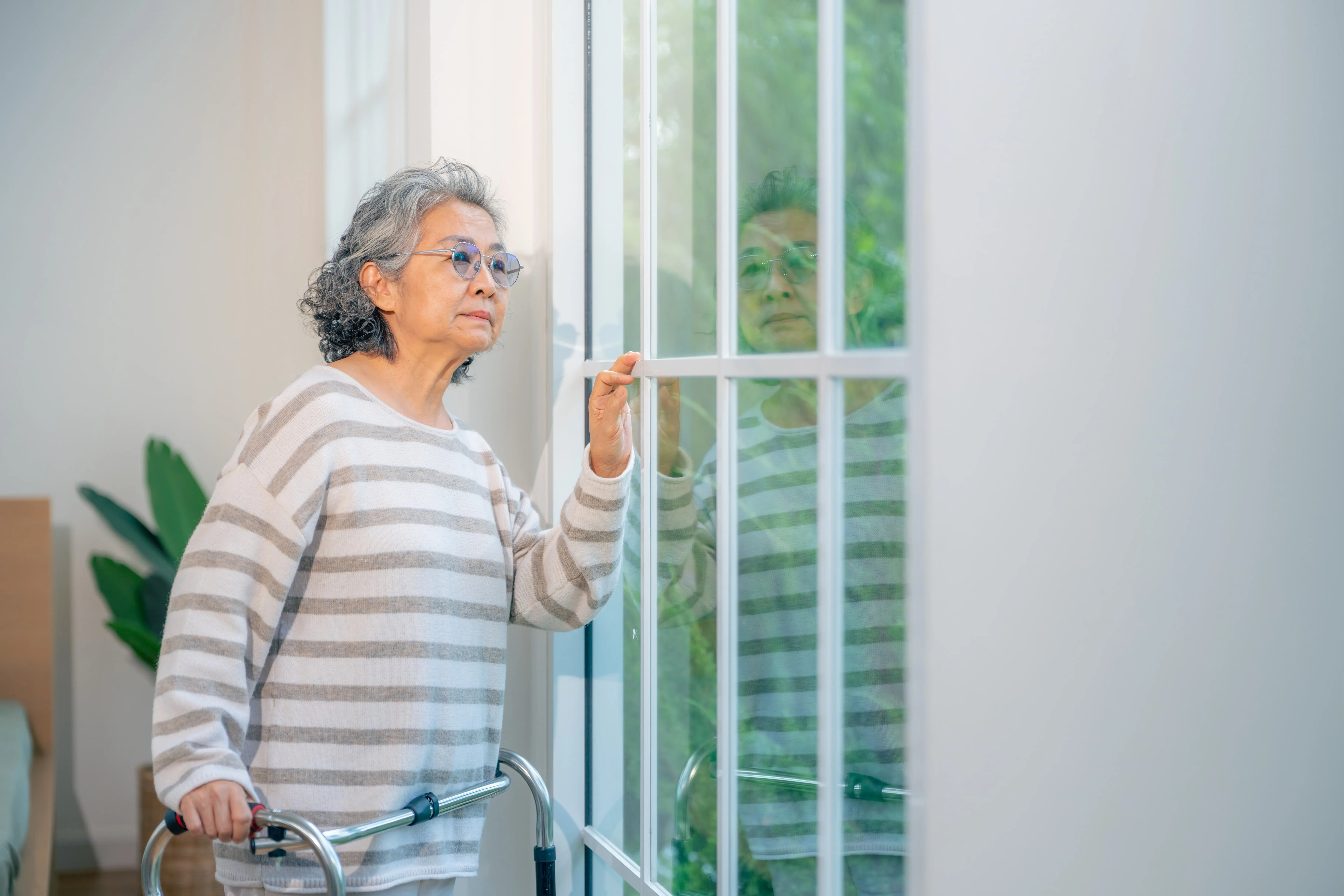 Older adult using a walker independently at home.