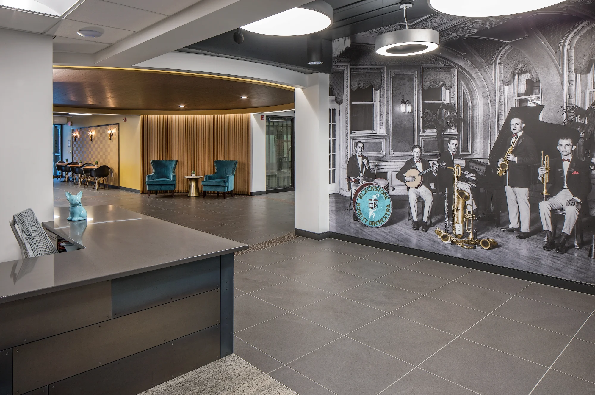 The Conrad apartment lobby in Omaha with a reception desk and a black-and-white mural of a vintage jazz band