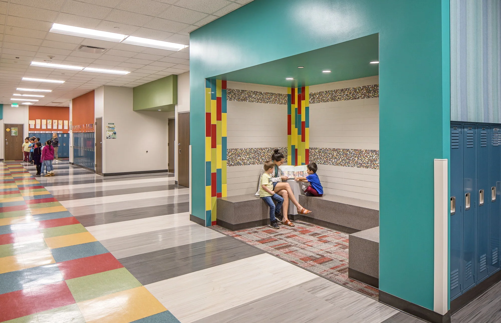 Corridor nook with a teal accent wall, bench seating and blue lockers