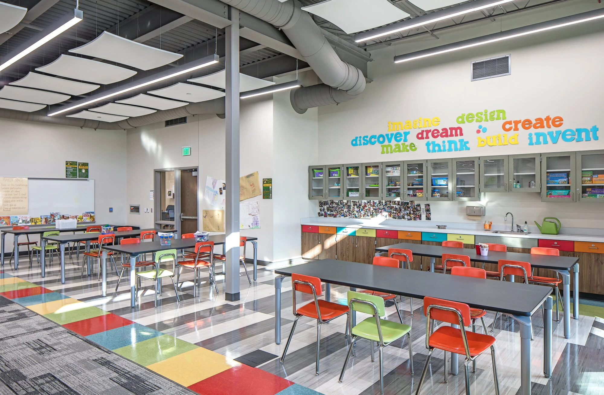 Makerspace with colorful chairs, high tables and a word-cloud wall graphic