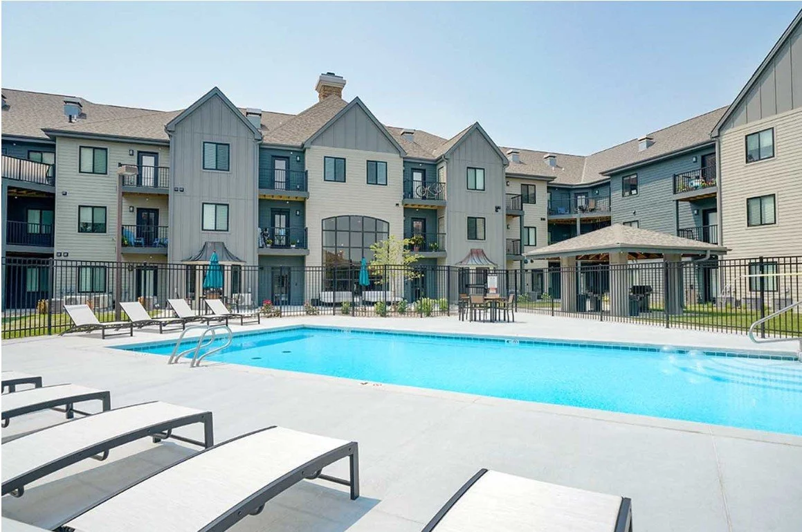 Outdoor swimming pool and lounge chairs in the courtyard of The Knock apartments