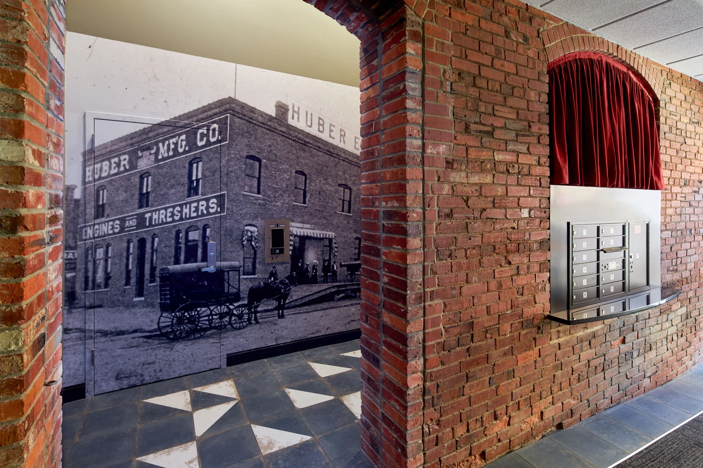 Historic brick entry at The Marquee Lofts in Lincoln with a vintage photo mural and patterned tile floor