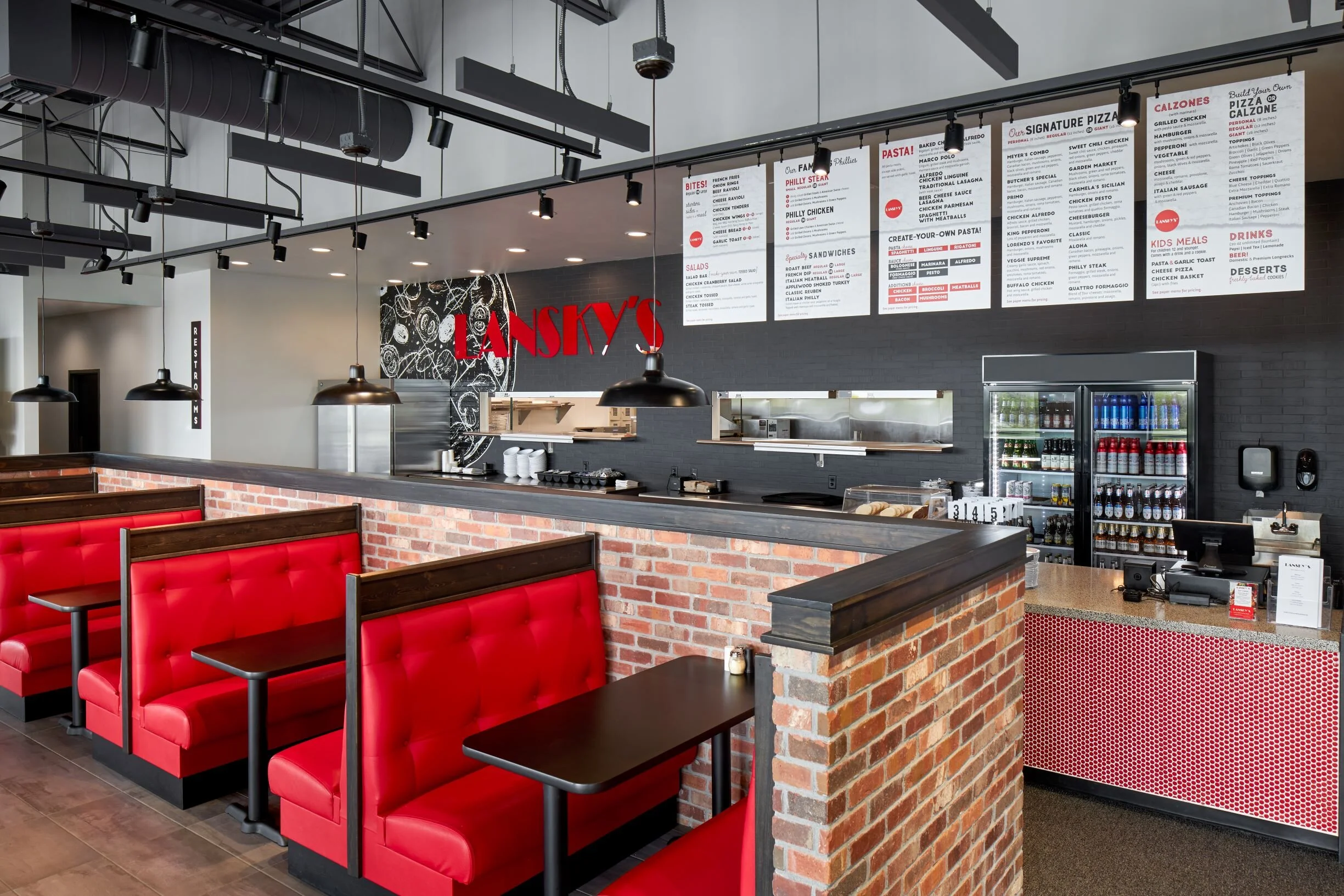 Order counter with menu boards, red booths and brick half-wall
