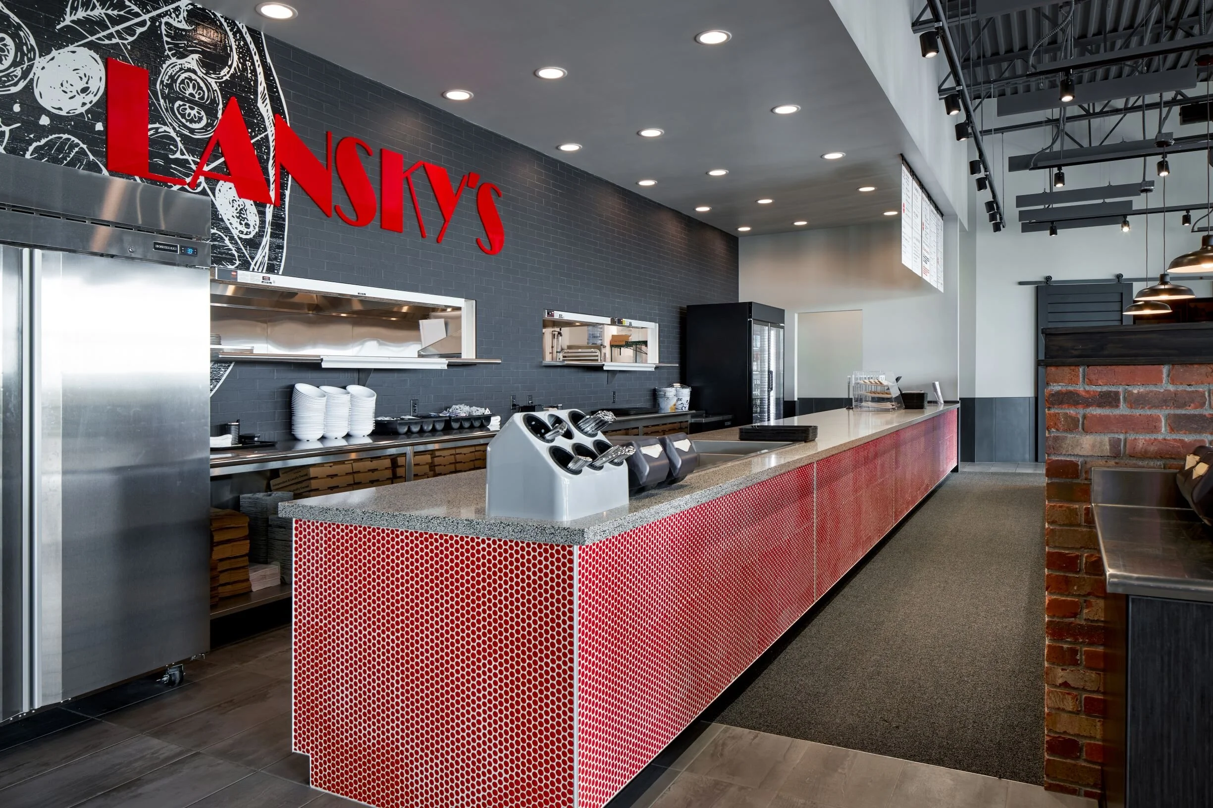 Lansky's service counter with a red tile front, brick wall and the restaurant logo
