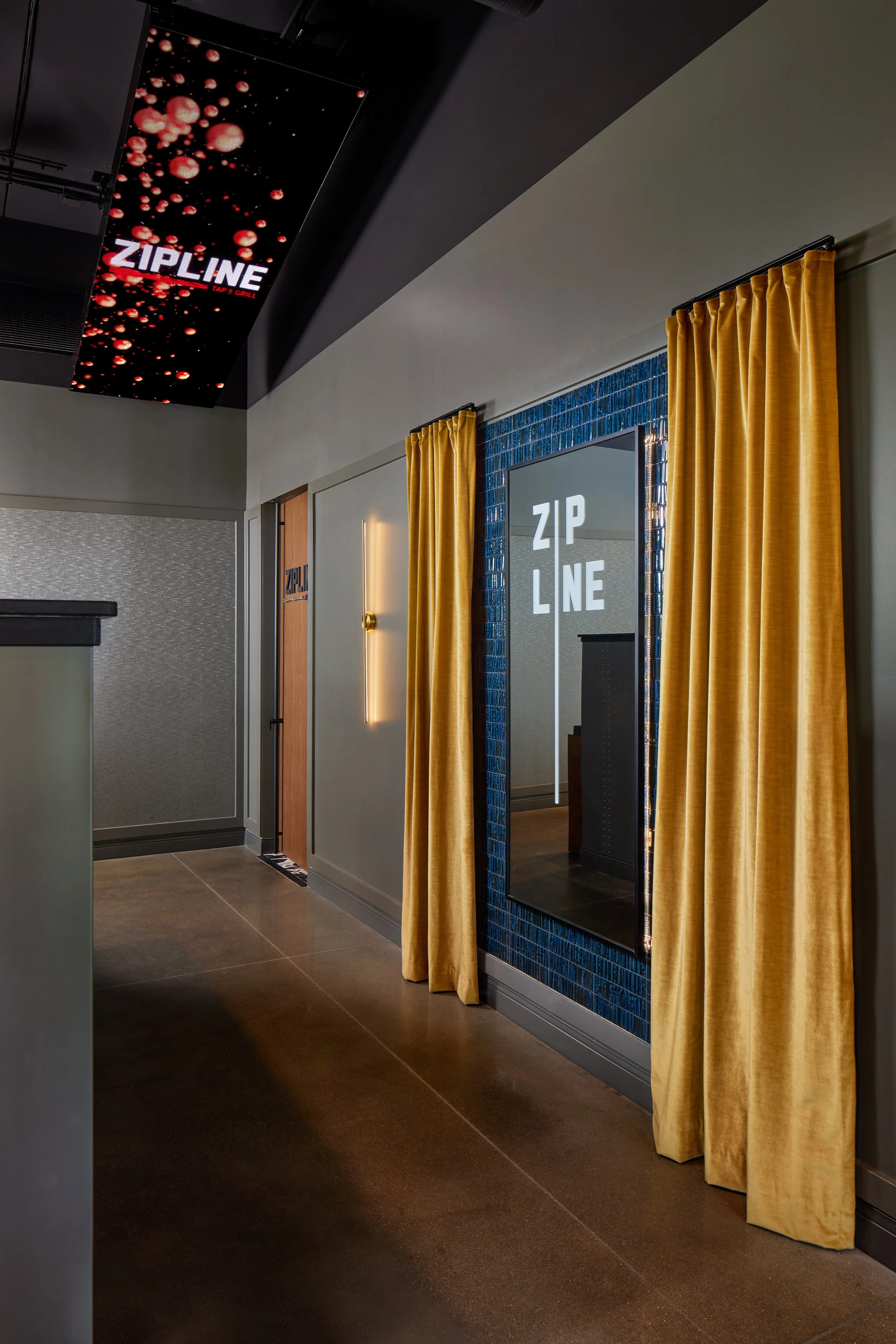 Entry vestibule with gold curtains and a Zipline sign